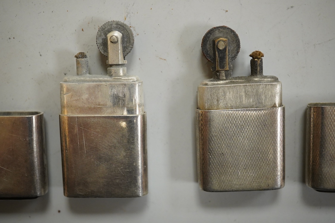 A near pair of George VI silver mounted lighters, each inscribed 'The Howitt Lighter', by Dudley Russell Howitt, Sheffield, 1946, (one engine turned), 58mm.